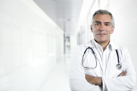 gray hair expertise handsome senior doctor hospital portrait white corridorの写真素材