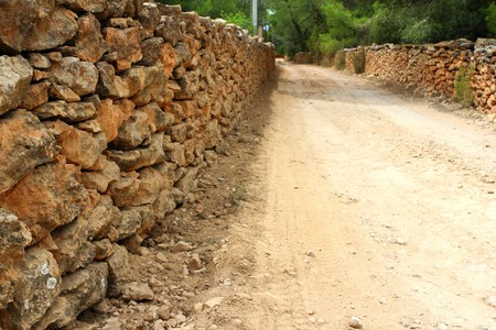 masonry stone wall fence around sand soil track in Formentera Balearic islandsの写真素材