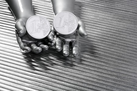 two silver euro coins in futuristic robot gray metallic hands bank metaphorの写真素材