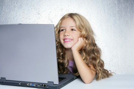 Student little school girl homework on laptop computer silver backgroundの写真素材