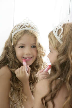 princess little girl painting makeup lipstick on the mirrorの写真素材