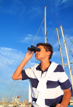 binoculars teenager boy on boat marina in blue summer vacationの写真素材