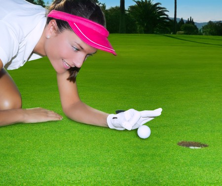 Golf green hole course woman humor flicking hand a ball inside in short puttの写真素材