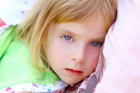 girl lying on pillow beautiful blue eyes toddler looking cameraの写真素材