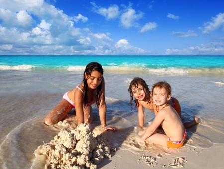three little girls mixed ethnicity playing tropical beach Caribbean seaの写真素材