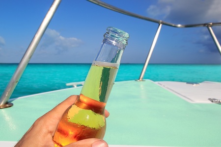 beer on hand Caribbean in boat bow turquoise sea enjoying vacationの写真素材