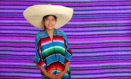Latin mexican hispanic sombrero poncho woman over serape purple backgroundの写真素材