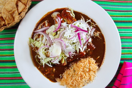 enchiladas of mole and rice Mexican food colorful tableclothの写真素材