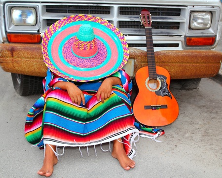Lazy nap mexican guy sleeping on grunge car with guitar and ponchoの写真素材