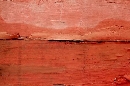 aged weathered wood painted in red orange color background textureの写真素材