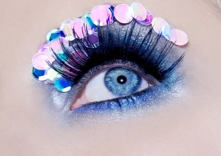 Blue eye macro closeup makeup sequins colorful fashion detailの写真素材