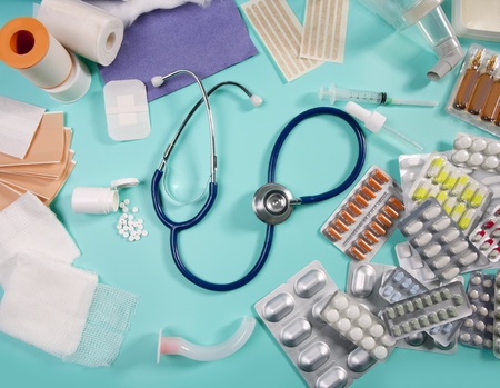 blister of medical pills and pharmaceutical stuff with stethoscope over green backgroundの写真素材