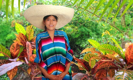 Latin mexican hispanic woman with sombrero and poncho in rainforest jungleの写真素材