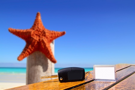 Car rental keys on wood table with blank paper in vacation with starfish of Caribbean beachの写真素材