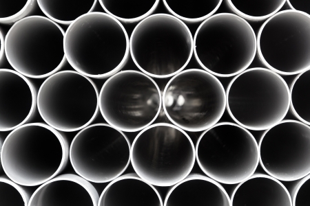 gray PVC tubes plastic pipes stacked in rows patternの写真素材