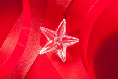 christmas glass star on red ribbon backgroundの写真素材