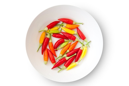 colorful chili peppers plate isolated on white backgroundの写真素材
