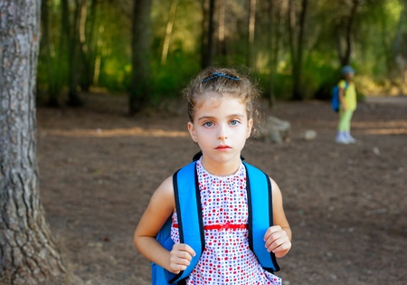 Children girl hiking with backpack in autumn forestの写真素材