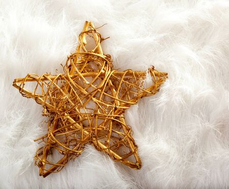 Christmas golden star over white fur backgroundの写真素材