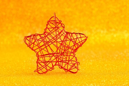 christmas golden star of wire over golden glitter backgroundの写真素材
