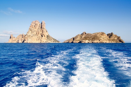Es Vedra islet and Vedranell islands in blue Mediterranean boat wakeの写真素材
