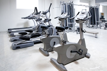 elliptical cross trainer, stationary bicycle and treadmill in gym
