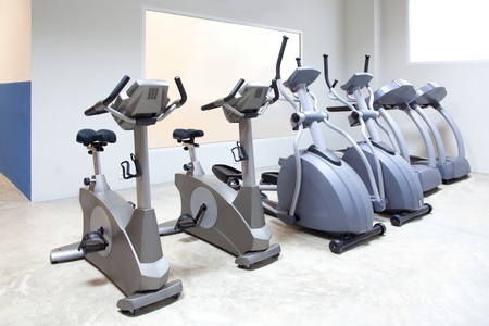 elliptical cross trainer, stationary bicycle and treadmill in gym