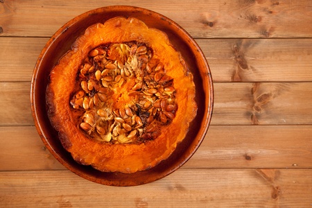 cutted half pumpkin roasted pumpkin on pottery clay dishの写真素材