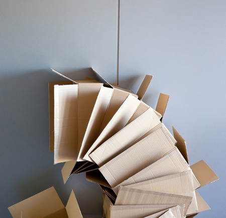 carton open boxes stacked on curved circle shape on gray wallの写真素材