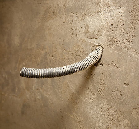 electrical coil conduit pipe on box embedded in the cement mortar wallの写真素材