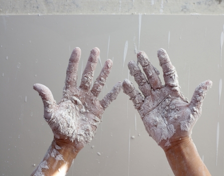Astist plastering man hands with white dried cracked plaster texture in fingersの写真素材