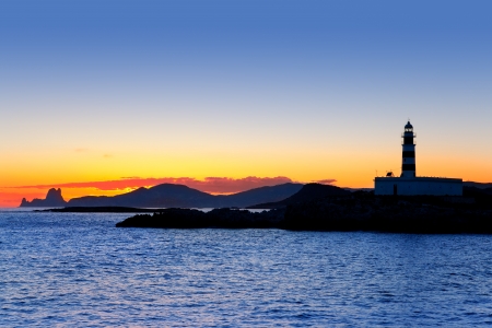 Ibiza island sunset with freus lighthouse and Es Vedra in backgroundの写真素材