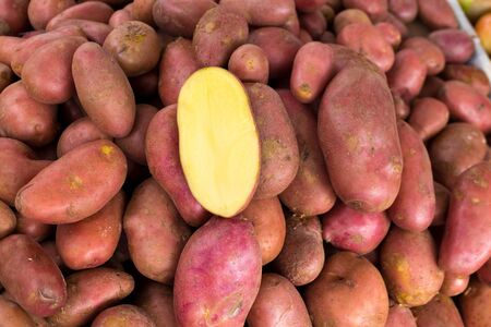 Red potatoes in a market display with half cutted in centerの写真素材