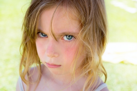 Angry blond children girl portrait looking at cameraの写真素材