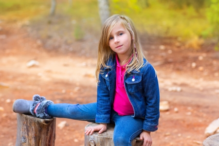 children girl relaxed on a tree trunk in the forest outdoorの写真素材