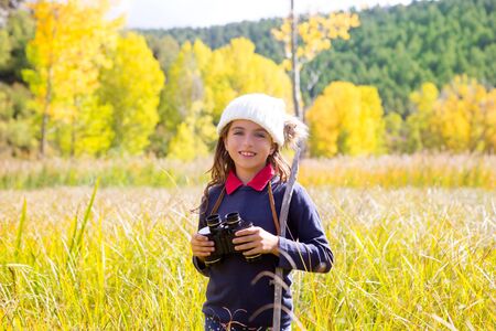 Explorer binocular kid girl in yellow autumn nature outdoorの写真素材