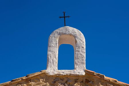 Christian cross on whitewashed arch at village church in Cuenca Spainの写真素材