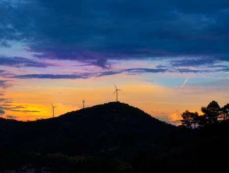 Sunset mountain with electric windmills aerogenerators backlight