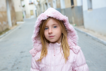 Child girl tourist walking in traditional Spain village pink winter fur hoodの写真素材