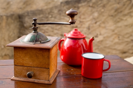 retro old coffee grinder with vintage teapot and red cupの写真素材