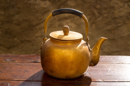 Antique brass teapot on vintage wooden aged tableの写真素材