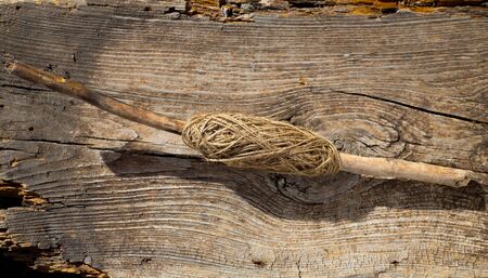 Traditional thread spool on tree stick branch over aged woodの写真素材