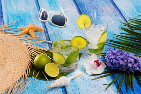 Cuban Mojito cocktail in tropical blue wood with sunglasses flowers and starfishの写真素材