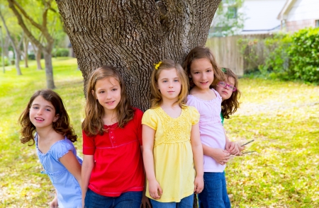 Children group friend girls friends playing on tree trunk at the park outdoorの写真素材