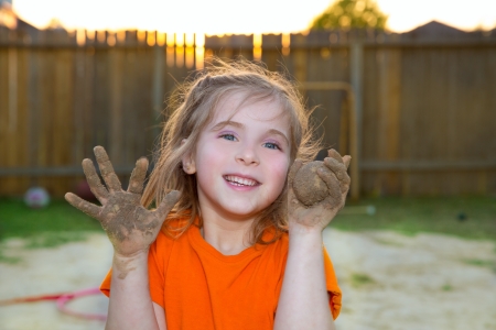 children girl playing with mud sand ball and dirty hands smiling happyの写真素材