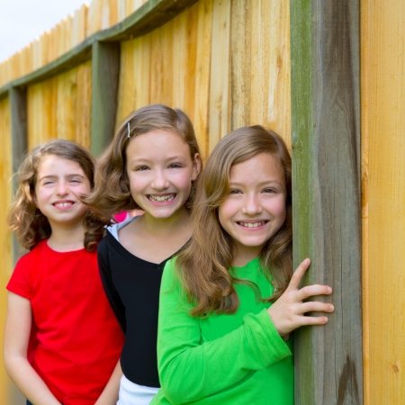 Grils group in a row smiling in a wooden fence outdoorの写真素材