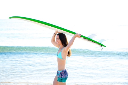 Surf beautiful girl with green surfboard in beach shore