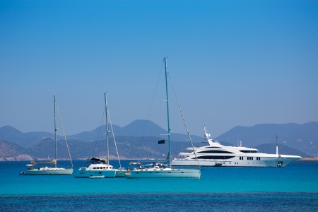 Ibiza coast view from Formentera with anchor boats in blue summer dayの写真素材