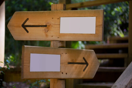 Wooden road sign with two opposite arrow directions with blank copy spaceの写真素材