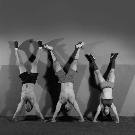 Handstand push-up group pushups workout top position at gymの写真素材